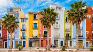 Situada entre Alicante y Benidorm, Villajoyosa (La Vila Joiosa) conserva la esencia de un antiguo pueblo pesquero. Su casco histórico, declarado Bien de Interés Cultural, destaca por las fachadas de colores que antaño ayudaban a los marineros a reconocer sus casas desde el mar | Estancias Alicante
